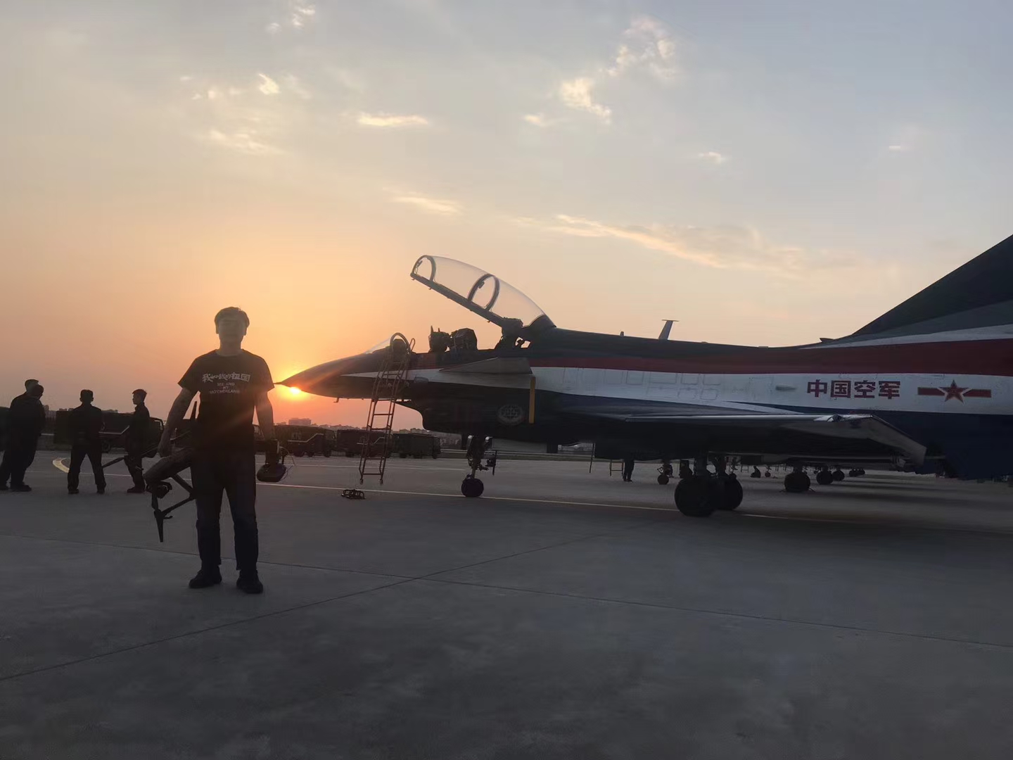 护航拍摄现场：夕阳中的飞机与工作人员